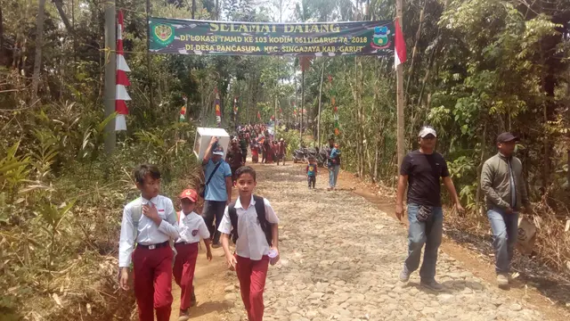 Sejumlah warga berjalan di jalan baru dalam program TMMD di desa Pancasura