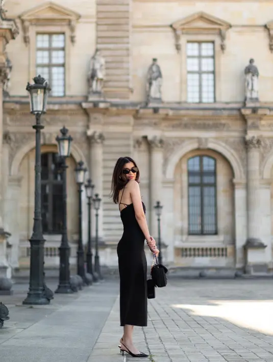 Kali ini, Sabrina Chairunnisa memilih mengenakan gaun hitam yang elegan. Bak parisian, ia mengenakan gaun hitam yang simpel, bertali spageti dan high slit di satu sisi kakinya. Kali ini, Sabrina menambahkan sunglasses dan handbag hitam yang ditentengnya. Foto: Instagram.