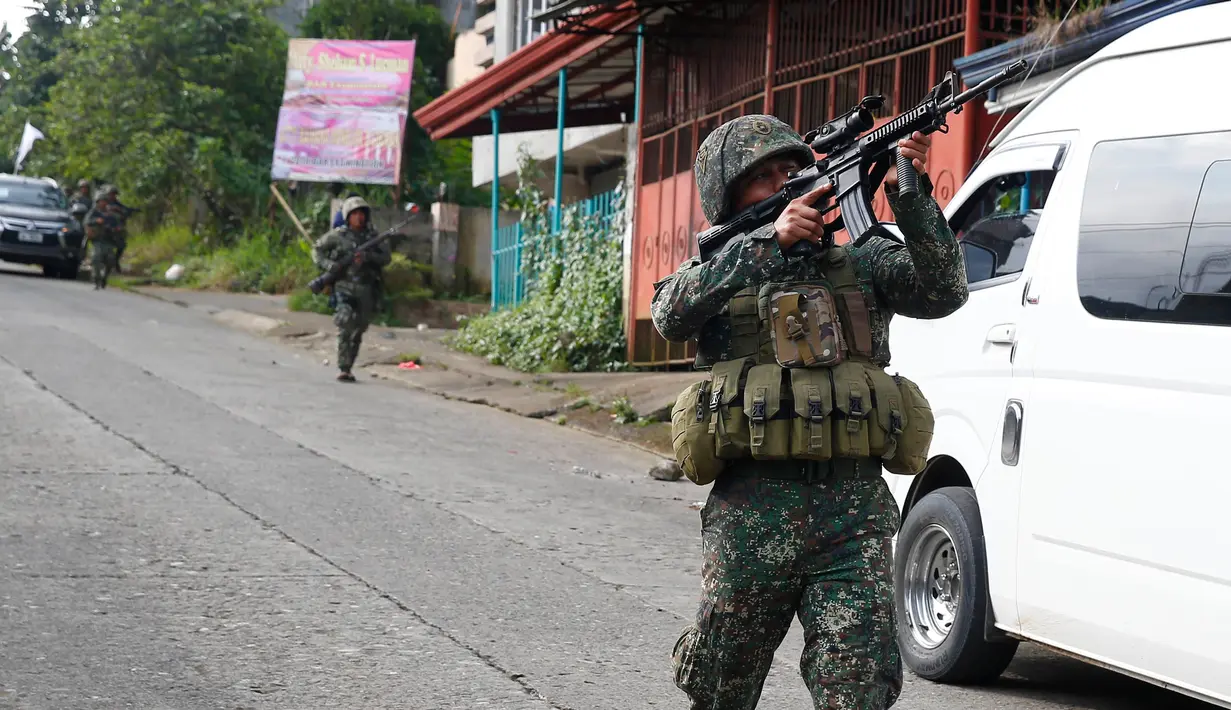 Tentara Filipina mengarahkan senjatanya saat bertempur melawan militan maute di kota Marawi, (28/5). Pasukan Filipina melancarkan serangan udara pada hari Minggu untuk mengusir militan yang terkait dengan kelompok ISIS. (AP Photo/Bullit Marquez)