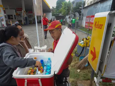Sejumlah petugas stasiun pengisian bahan bakar umum swasta terpaksa menjajakan produk dagangan di pinggir jalan di depan salah satu SPBU Shell, Jalan Gunung Sahari, Jakarta, Kamis (18/9/2025). (merdeka.com/Arie Basuki)