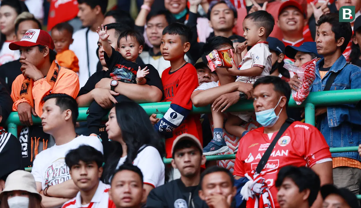 Suporter Cilik saat menyaksikan pertandingan Persija Jakarta melawan Arema FC pada laga BRI Liga 1 di Stadion Patriot Candrabhaga, Bekasi, Minggu (12/2/2023). Tribun penonton tertib tanpa asap membuat anak-anak bisa hadir langsung ke stadion. (Bola.com/M Iqbal Ichsan)
