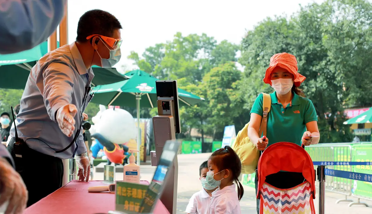 Pengunjung menjalani pemeriksaan suhu tubuh sebelum memasuki area Taman Safari Chimelong di Guangzhou, Provinsi Guangdong, China, Kamis (30/4/2020). Taman Safari Chimelong kembali dibuka untuk pengunjung dengan menerapkan langkah-langkah ketat pencegahan pandemi COVID-19. (Xinhua/Lu Ye)