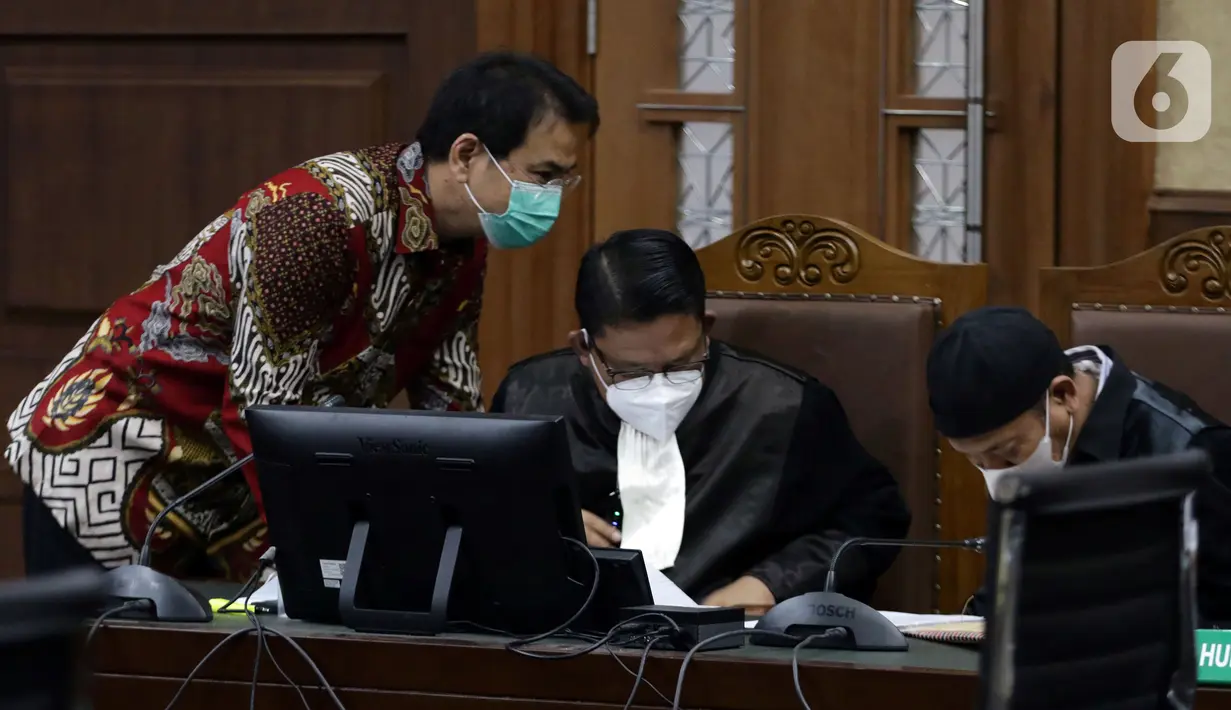Mantan Wakil Ketua DPR Azis Syamsuddin (kiri) saat mengikuti sidang lanjutan di Pengadilan Tipikor Jakarta, Kamis (23/12/2021). Azis Syamsuddin merupakan terdakwa dugaan suap penanganan perkara korupsi di Lampung Tengah. (Liputan6.com/Helmi Fithriansyah)