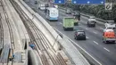 Pekerja menyelesaikan pembangunan proyek kereta api ringan atau LRT di kawasan Kampung Makasar, Jakarta, Kamis (26/7). Proyek LRT Jakarta diusahakan selesai sesuai target, yakni seminggu sebelum Asian Games 2018. (Liputan6.com/Faizal Fanani)