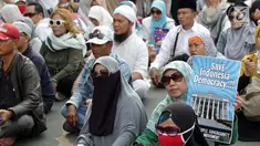 Massa berkumpul menyampaikan pendapat terkait sidang perselisihan hasil pilpres 2019 di sekitar Patung Arjuna Wiwaha Jalan Medan Merdeka Barat, Jakarta, Jumat (14/6/2019). Massa meminta sidang berlangsung adil. (Liputan6.com/Helmi Fithriansyah)