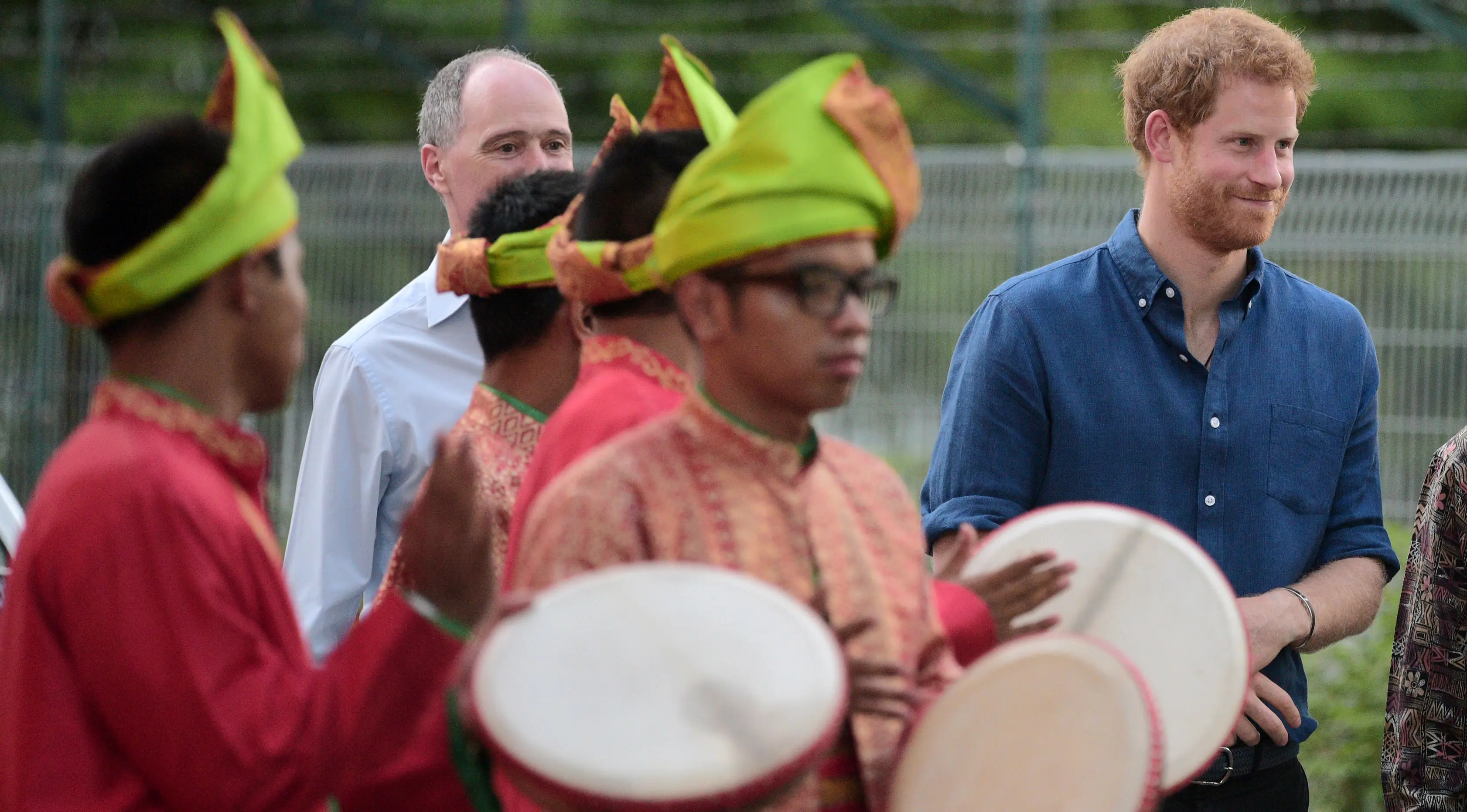Pangeran Harry disuguhkan hiburan oleh 10 penabuh rebana saat mengunjungi Jamiyah Children's Home di Singapura, Minggu (4/6). Dalam kesempatan tersebut, adik dari Pangeran William itu ikut merasakan buka puasa bersama dengan komunitas muslim. (POOL/AFP)
