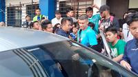 Ciro Alves berjalan melewati Bobotoh usai menggelar latihan bersama Persib Bandung dengan tangan ditopang alat bantu, Minggu (19/6/2022). (Bola.com/Erwin Snaz)
