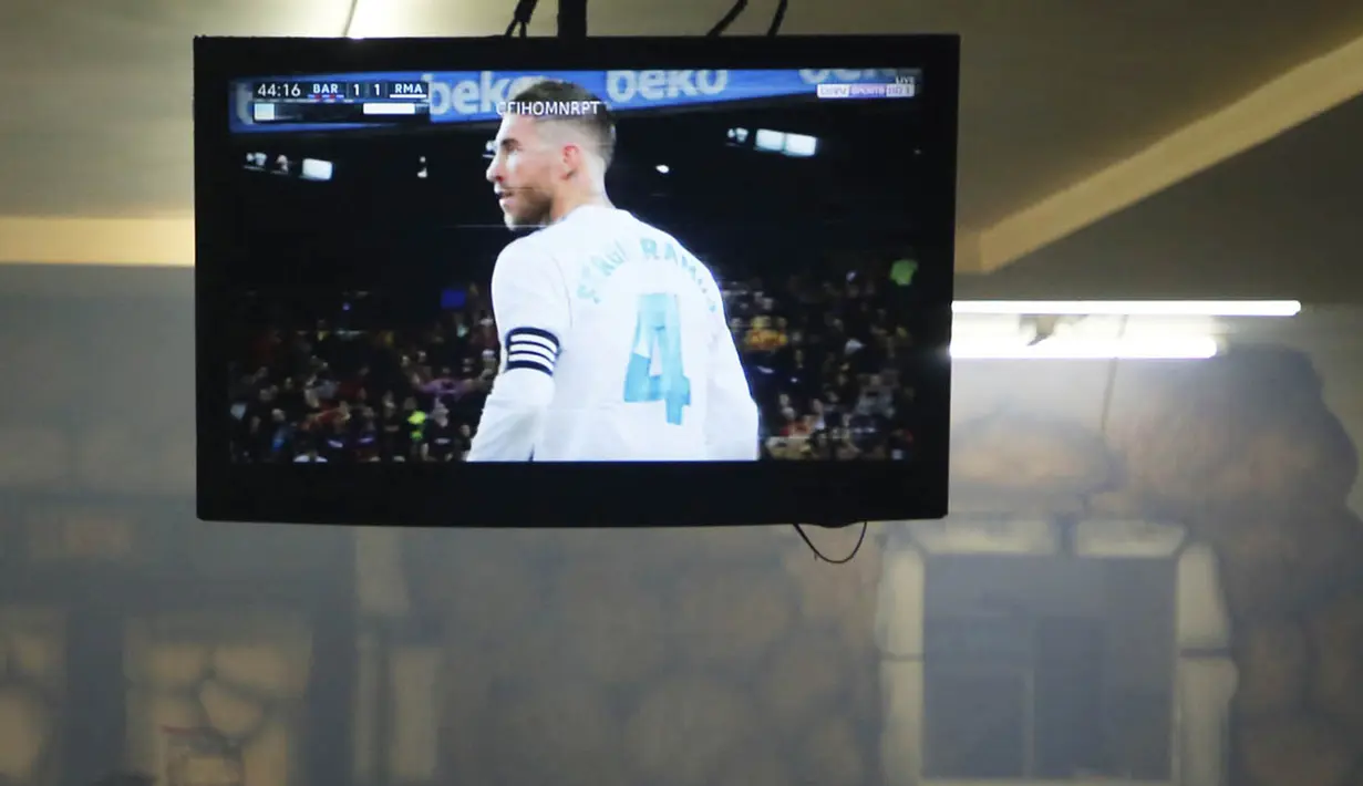 Sebuah TV di Palestina menayangkan laga El Clasico antara Barcelona melawan Real Madrid di West Bank City, Ramallah, Minggu (6/5/2018). Konflik perang tak menyurutkan fenomena El Clasico. (AFP/Abbas Momani)