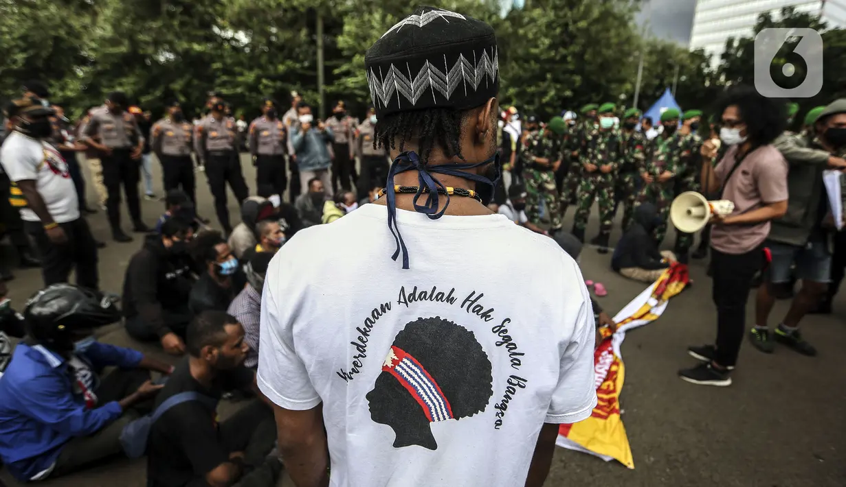 Tentara dan polisi menjaga masyarakat Papua yang berorasi saat memperingati Operasi Trikora 19 Desember 1961 di Patung Kuda, Jakarta, Sabtu (19/12/2020). Dalam aksinya, massa menuntut 15 isu besar. (Liputan6.com/Johan Tallo)