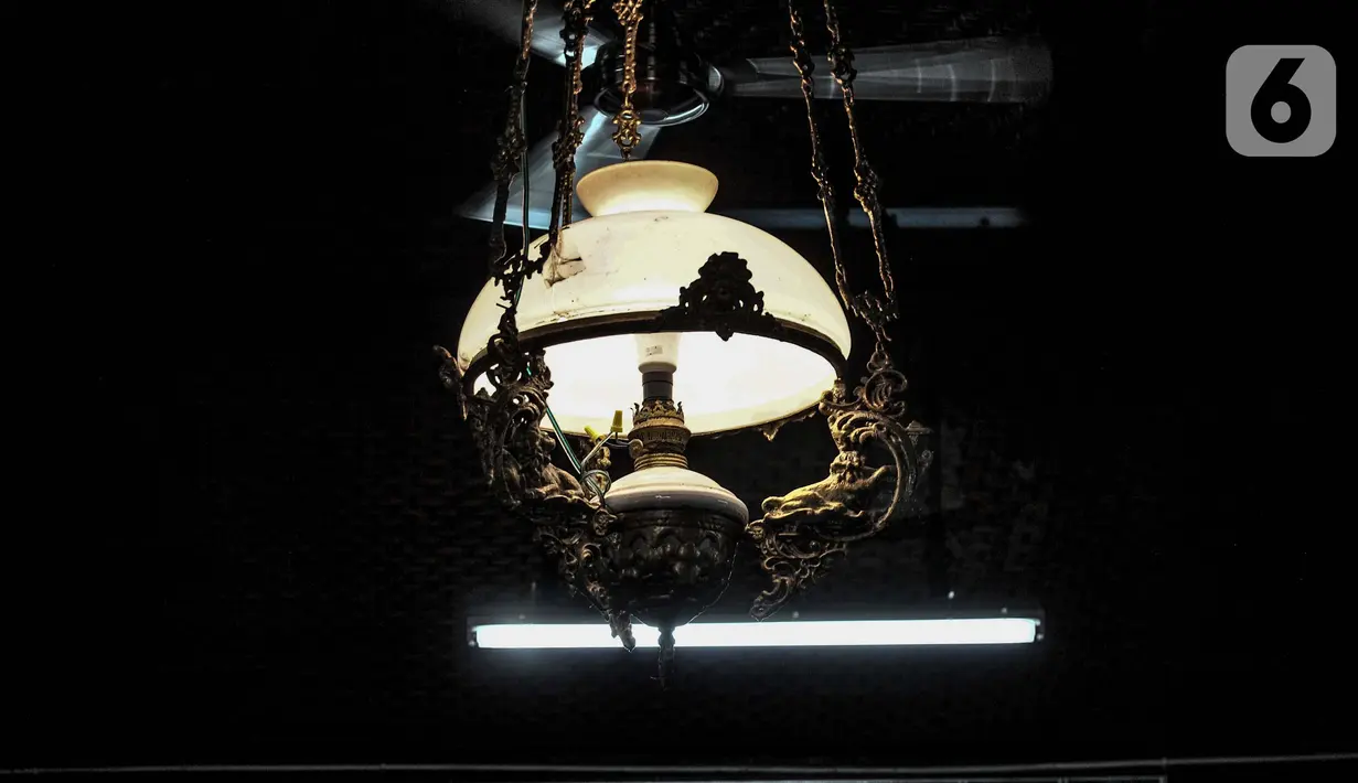 Lampu kuno di bangunan utama Masjid Al Alam, Jakarta, Kamis (22/4/2021). Saat ini bangunan utama masjid masih serupa aslinya, mempertahankan mihrab dan mimbar, jumlah pintu dan jendela, 4 tiang utama (soko guru) terbuat dari kayu jati, setengah dinding dari bilik bambu. (merdeka.com/Iqbal S.Nugroho)