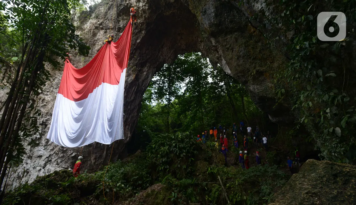 Pegiat panjat tebing membentangkan Bendera Merah Putih memperingati HUT ke-75 RI di Tebing Kutalingkung, Jawa Barat, Senin (17/8/2020). Pengibaran bendera untuk menyelamatkan tebing Kutalingkung yang memiliki potensi destinasi wisata  dari aktivitas pertambangan. (merdeka.com/Imam Buhori)