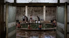 Pengunjung menikmati kolam renang air hangat dari belerang di Hamam Alli, Mosul, Irak, (27/4). Sebelum ISIS mengambil alih Hamam Alil pada 2014, warga Irak selalu mengunjungi spa bersejarah di selatan Mosul ini. (AP Photo/Bram Janssen)