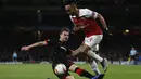 Damien da Silva mencoba meghentikan Aubameyang pada leg kedua,babak 16 besar Liga Europa yang berlangsung di Stadion Emirates, London, Jumat (15/3). Arsenal menang 3-0 atas Rennes. (AFP/Ian Kington)