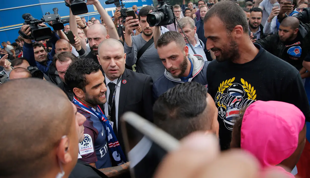 Bek baru PSG, Dani Alves menyapa para fans usai konferensi pers di stadion Parc des Princes di Paris, Prancis, (12/7). Alves menandatangani kontrak berdurasi dua tahun dengan Paris St-Germain. (AP Photo/Michel Euler)