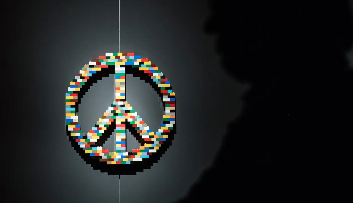 Seseorang berdiri di dekat patung "Peace Symbol" yang terbuat dari susunan balok lego pada pameran Art of the Brick di Turin, Italia, Kamis (15/11). Pameran tersebut menampilkan berbagai patung lego karya seniman AS, Nathan Sawaya. (MARCO BERTORELLO/AFP)