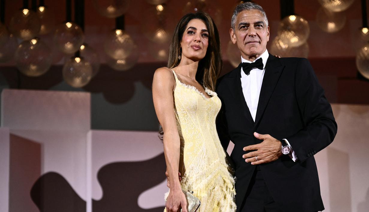 Aktor George Clooney dan istrinya Amal Clooney menghadiri pemutaran perdana film 'Wolfs' pada Festival Film Venice ke-81 di Venesia, Italia, pada Minggu (1/9/2024).  (Photo by Marco BERTORELLO / AFP)