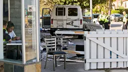 Penyidik kepolisian mewawancarai saksi mata setelah mobil van yang menabrak kerumunan orang di depan sebuah restoran di Los Angeles, Minggu (30/7). Sopir kendaraan itu telah ditangkap dan dibawa ke rumah sakit untuk diperiksa (AP Photo/Damian Dovarganes)