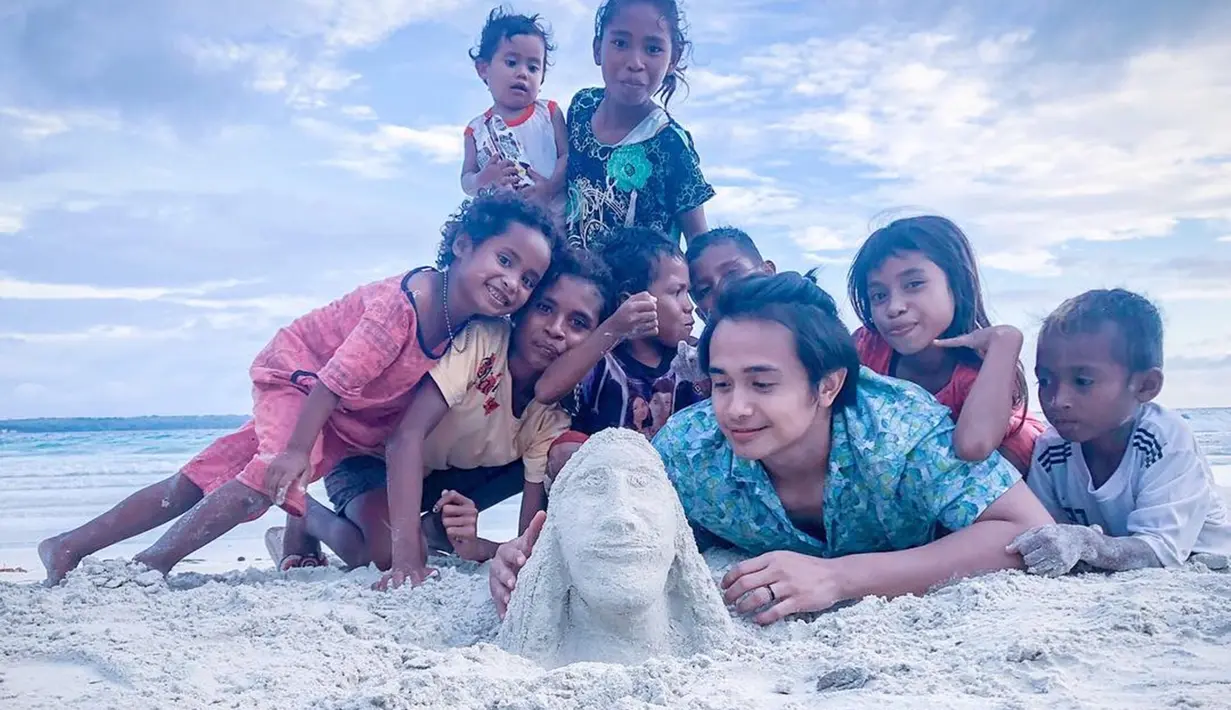 Suami dari Jennifer Jill ini memang terkenal sangat ramah dengan siapapun. Pembawaan pribadi yang ramah ini, membuat Ajun banyak disukai orang. Termasuk oleh anak-anak yang tinggal di pinggir pantai. Ajun terlihat menikmati suasana pantai bersama anak-anak tersebut. (Liputan6.com/IG/@ajunperwira)