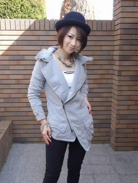 Masako Mizutani berpose dengan paduan jaket abu-abu dan topi hitam. Masako Mizutani telah menerima banyak pekerjaan dari industri modeling sejak namanya terkenal. Facebook/Masako Mizutani)