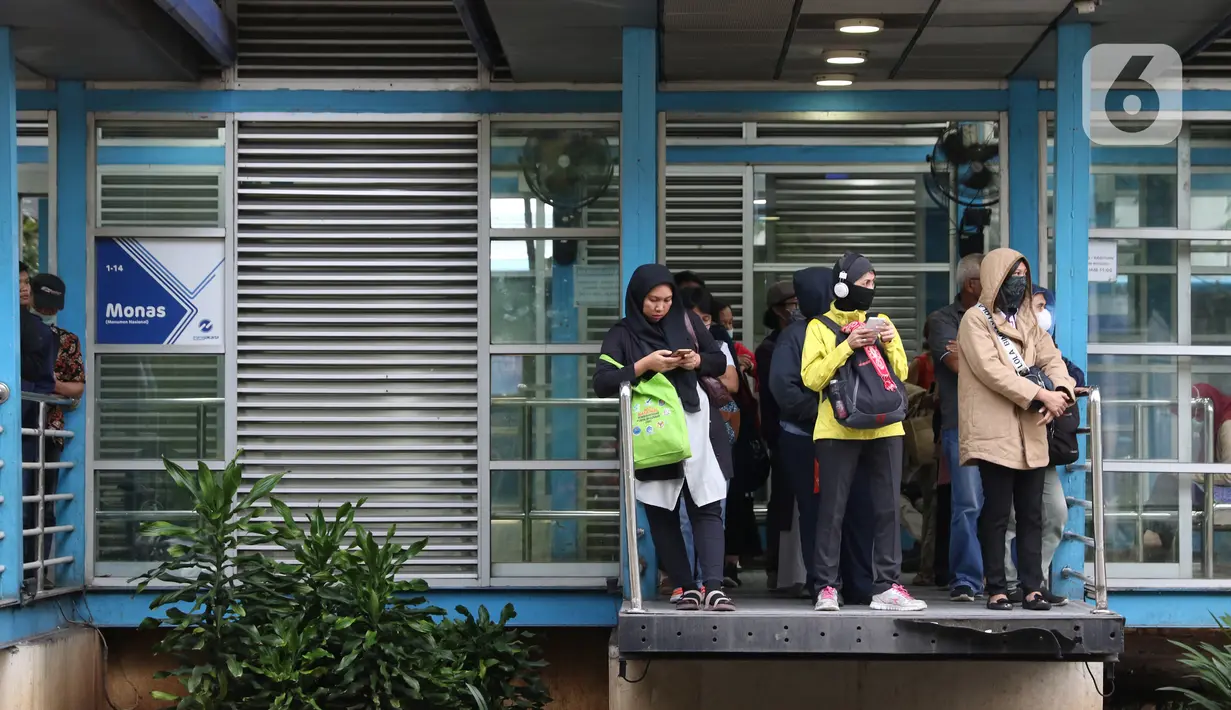 Pengguna moda transportasi Transjakarta menanti kedatangan bus dengan tetap menjaga jarak aman di Halte Monas, Jakarta, Rabu (18/3/2020). Warga kini lebih waspada dalam menanggapi penyebaran virus corona COVID-19 seiring bertambahnya kasus tersebut di Tanah Air. (Liputan6.com/Helmi Fithriansyah)