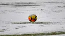 Bola yang diselimuti salju terlihat di Allianz Stadium di Turin, Italia, (25/2). Juventus kini berada di posisi kedua dengan 65 poin, selisih satu poin dengan Napoli di puncak klasemen. (AFP Photo/Alberto Pizzoli)