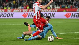 Momen gelandang Red Star Mirko Ivanic dilanggar kiper Lille Berke Ozer pada pertandingan Liga Europa 2025/2026. (Andrej ISAKOVIC / AFP)