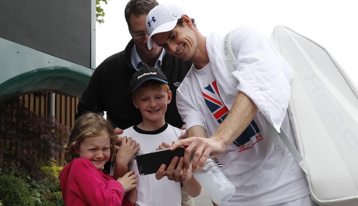 Petenis Inggris Raya, Andy Murray melakukan sesi foto selfie bersama fans usai berlatih di Wimbledon tennis club, London, (1/7/2017). Turnament Wimbledon 2017 akan berlangsung pada  3-16 Juli 2017. (AFP/Adrian Dennis)