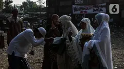 Warga bersalaman saat merayakan Idul Fitri di Pancoran Buntu II, Jakarta Selatan. Kamis (13/5/2021). Mayoritas umat Muslim di Indonesia melaksanakan Sholat Id sesuai dengan ketetapan pemerintah pada Rabu (13/5/2021). (Liputan6.com/Johan Tallo)