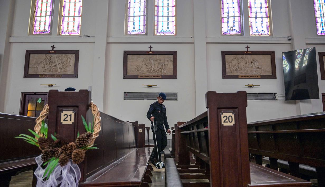Sebagai informasi, kegiatan ini juga menjadi bagian pelaksanaan Operasi Lilin Semeru 2025 yakni pengamanan Nataru. Tampak dalam foto, personel dari unit Gegana dan Jihandak Brimob Polda Jawa Timur melakukan pemeriksaan di dalam area Gereja Katedral Hati Kudus Yesus, atau yang dikenal secara lokal sebagai gereja "Hati Kudus Yesus", Surabaya, pada Rabu 24 Desember 2025. (JUNI KRISWANTO/AFP)