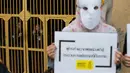 Penjaga menonton aktivis Amnesty International melakukan aksi tolak hukuman mati dengan suntik di depan penjara Bang Kwang di Nonthaburi, Bangkok (19/6). Mereka mengutuk hukuman mati terhadap Theerasak Longji pada 18 Juni 2018. (AFP PHOTO / Romeo Gacad)