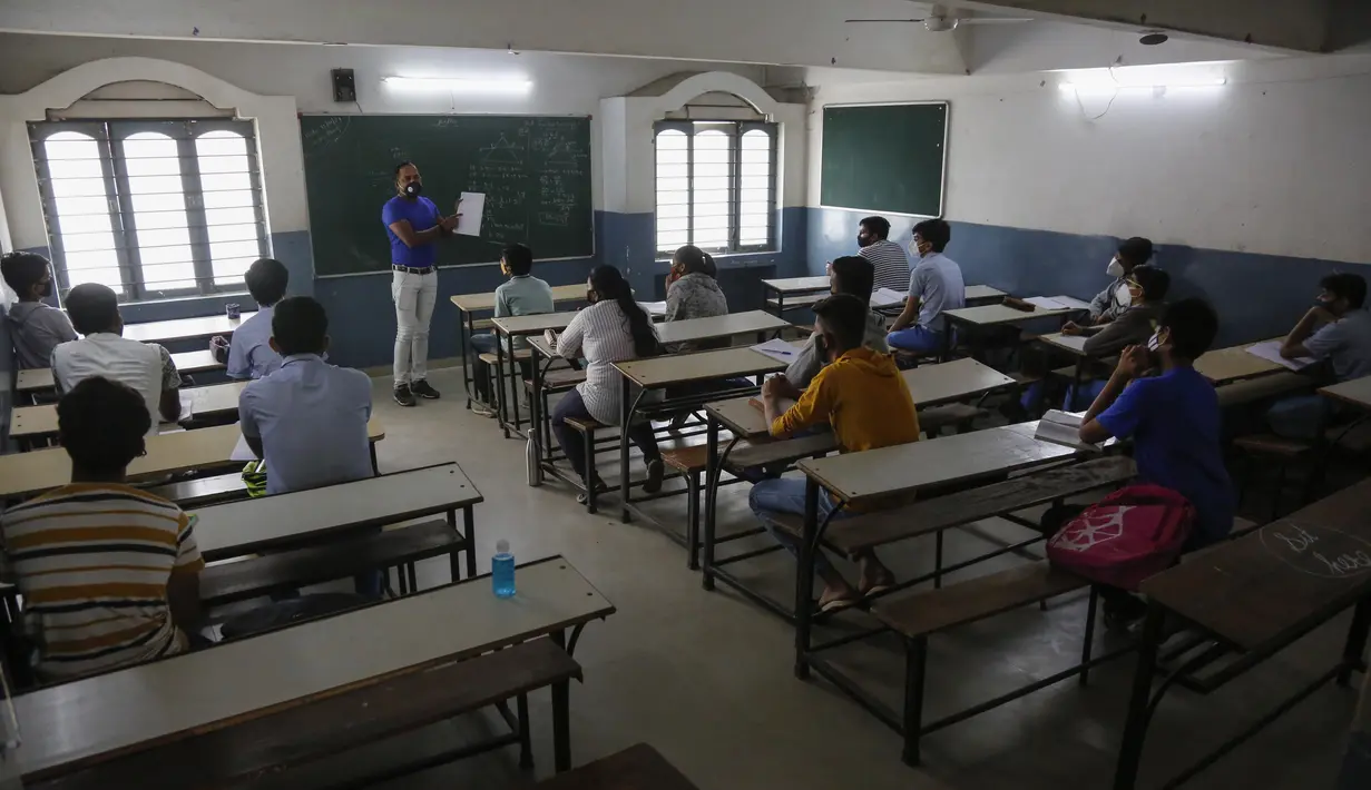 Suasana kegiatan belajar mengajar di kelas saat sekolah dibuka kembali setelah ditutup selama berbulan-bulan karena pandemi COVID-19 di Ahmedabad, India, Senin (11/1/2021). Negara bagian Gujarat telah membuka kembali sekolah hanya untuk kelas 10 dan 12. (AP Photo/Ajit Solanki)