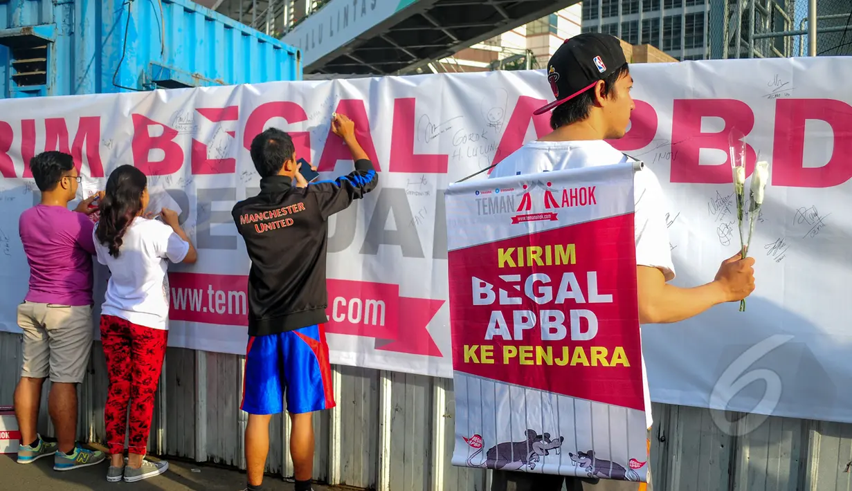 Warga menandatangani spanduk bertuliskan "Kirim Begal APBD" sebagai bukti dukungan kepada Gubernur DKI Jakarta Basuki Tjahaja Purnama di bawah jembatan Bundaran HI, Jakarta, Minggu (8/3/2015). (Liputan6.com/Yoppy Renato) 