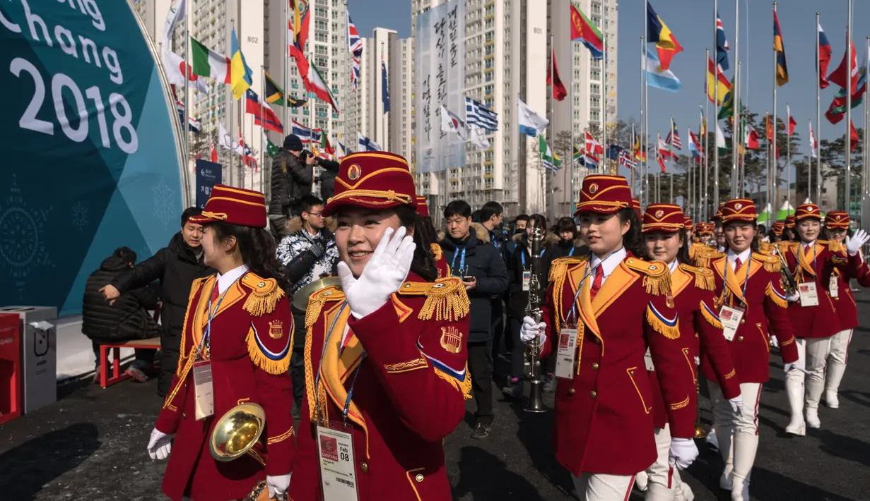Pemandu sorak Korea Utara melambaikan tangan usai upacara penyambutan atlet asal negaranya di Desa Olimpiade, Gangneung, Korea Selatan, Kamis (8/2). (JUNG Yeon-Je / AFP)