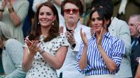 Duchess of Cambridge Kate Middleton dan Duchess of Sussex Meghan Markle bertepuk tangan saat menyaksikan pertandingan Serena Williams dan Angelique Kerber di kejuaraan  tenis Wimbledon di London, Inggris, (14/7). (AP Photo/Andrew Couldridge)