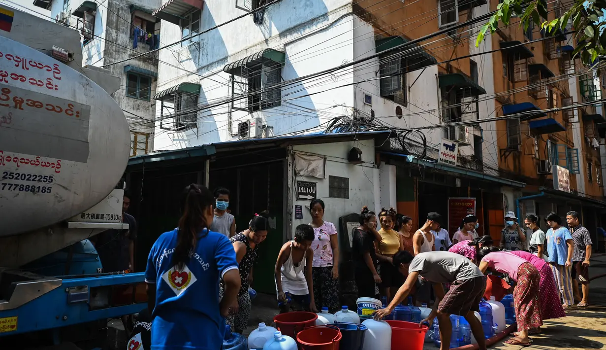 Orang-orang berbaris untuk mengisi wadah dengan air di Yangon, Myanmar (14/3/2022). Ribuan orang menghadapi kekurangan air karena pemadaman listrik di kota tersebut. (AFP/STR)