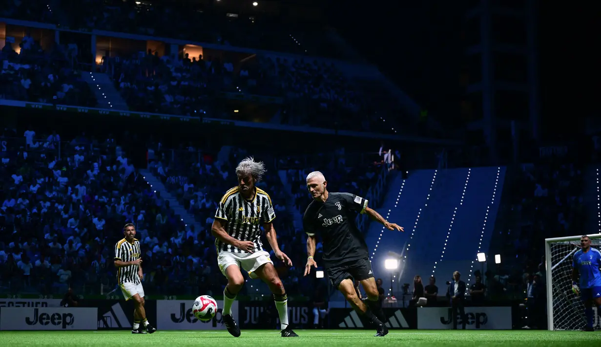 Aksi mantan pemain Juventus yang mewakili tim putih, Moreno Torricelli (kiri) dan Fabrizio Ravanelli dari Tim Hitam dalam laga persabatan mini soccer 7 lawan 7 di Pala Alpitour, Turin, Rabu (11/10/2023) dini hari WIB yang diikuti para legenda Juventus dalam rangkaian perayaan 100 tahun Keluarga Agnelli mengakuisisi Juventus. Hasil laga dimenangkan Tim Putih 9-6 atas Tim Hitam. (AFP/Marco Bertorello)