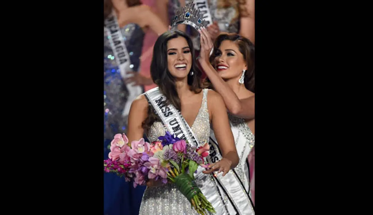 Miss Universe 2013, Gabriel Isrel saat menyematkan mahkota ke kepala Paulina Vega yang terpilih sebagai Miss Universe 2014 di FIU Arena, Doral, Miami, Minggu (25/1/2015). (AFP PHOTO/Timothy A. CLARY)