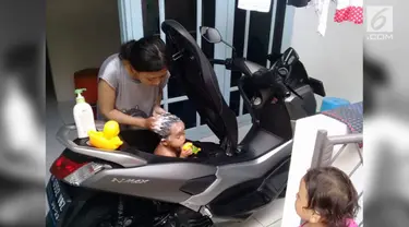 Siapa sangka bagasi motor bisa menjadi tempat mandi anak. Aksi ini dilakukan seorang Ibu dan menjadi viral di medsos.