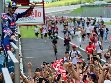 Pembalap Ducati Lenovo, Francesco Bagnaia melakukan selebrasi dengan para penggemarnya usai memenangi balapan MotoGP Italia di Mugello, 2 Juni 2024. (Marco BERTORELLO/AFP)