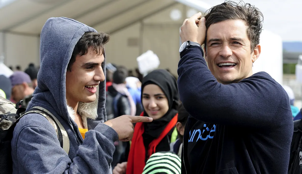 Duta UNICEF, Aktor Orlando Bloom (kanan) berbicara dengan Tariq Maria dari Damaskus, Suriah saat ia mengunjungi kamp transit migran di Gevgelija, Makedonia, 29 September 2015. (REUTERS/Ognen Teofilovski)