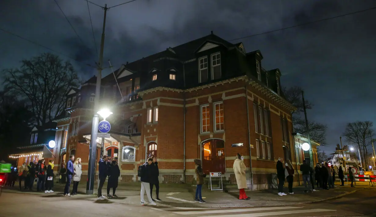 Warga mengantre untuk memberikan suara di luar TPS pada jam terakhir pemungutan suara dalam pemilihan umum di Amsterdam, Belanda, Rabu (17/3/2021). Pemilu digelar selama tiga hari untuk memungkinkan warga memilih dengan aman selama pandemi virus corona COVID-19. (AP Photo/Peter Dejong)