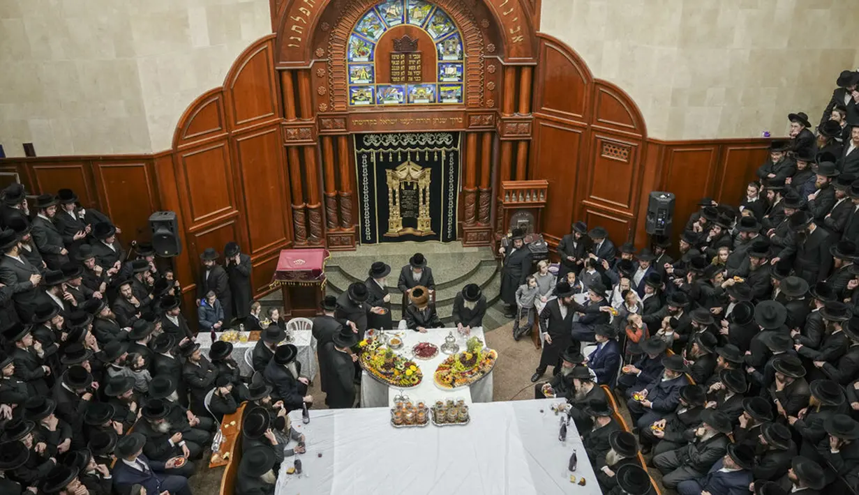 Umat Yahudi ultra-ortodoks dari dinasti Sadigura Hasidic merayakan Hari Raya Tu Bishvat atau Tahun Baru Pohon di Bnei Brak, Israel, 16 Januari 2022. Pada perayaan ini mereka duduk bersama para rabi di sekitar meja panjang dengan hidangan aneka jenis buah-buahan. (AP Photo/Ariel Schalit)
