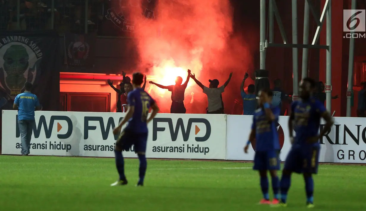Suporter tim Maung Bandung menyalakan suar saat menyaksikan laga Bhayangkara FC melawan Persib di Stadion Patriot Candrabhaga, Bekasi, Minggu (4/6). Persib kalah 0-2 dari Bhayangkara FC. (Liputan6.com/Helmi Fithriansyah)