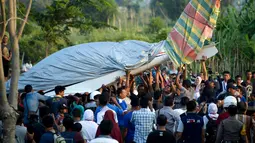 Warga mengevakuasi pesawat Shark Aero PK S 121 yang dipiloti gubernur Aceh, Irwandi Yusuf seusai mendarat darurat di kawasan Ujong Pancu, Aceh Besar, Sabtu ( 17/2). Belum diketahui penyebab pesawat tersebut harus mendarat darurat. (CHAIDEER MAHYUDDIN/AFP)