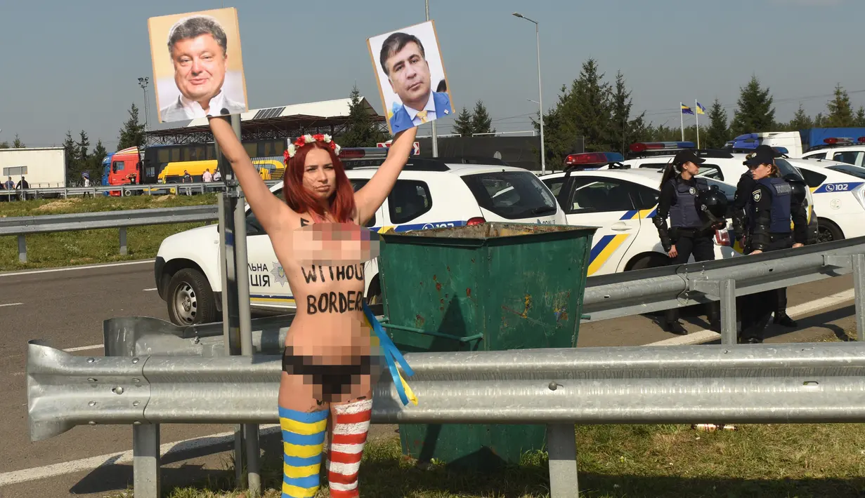 Aktivis perempuan Femen bertanjang dada membawa poster Presiden Ukraina Petro Poroshenko dan mantan Presiden Georgia Mikhail Saakashvili di perbatasan Ukraina-Polandia, di Ukraina, (10/9). (AFP Photo/Yuri Dyachyshyn)