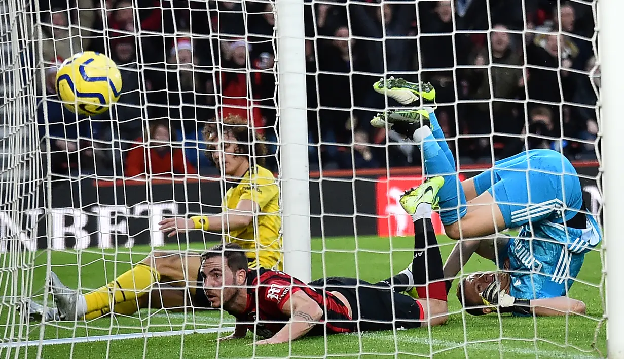 Pemain Bournemouth Dan Gosling (kiri) melewati kiper Arsenal Bernd Leno (kanan) saat mencetak gol pada pertandingan Liga Inggris di Stadion Vitality, Bournemouth, Inggris, Kamis (26/12/2019). Pertandingan berakhir dengan skor 1-1. (Glyn KIRK/AFP)