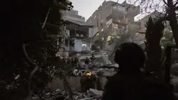 Hantaman rudal Iran menimbulkan kerusakan signifikan pada infrastruktur bangunan setinggi tujuh lantai tersebut. Tampak dalam foto, pasukan keamanan Israel dan tim penyelamat melakukan upaya pencarian korban di tengah reruntuhan bangunan tempat tinggal yang dihantam rudal Iran di Haifa, Israel, Minggu, 5 April 2026. (AP Photo/Ariel Schalit)