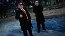 Dua pria berpakaian seperti pemimpin Korea Utara Kim Jong Un dan Presiden AS, Donald Trump bersiap menghadiri upacara pembukaan Olimpiade Pyeongchang 2018 di Pyeongchang, Korea Selatan (9/2). (AFP Photo/Brendan Smialowski)