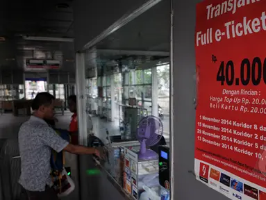 Seorang pengguna bus Transjakarta saat membeli e-ticketing di kasir, Jakarta, Sabtu (21/2/2015). PT Transportasi Jakarta (Transjakarta) menyatakan seluruh 12 koridor Transjakarta resmi menggunakan e-ticketing. (Liputan6.com/JohanTallo)