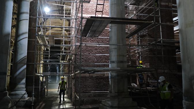 Para anggota tim restorasi bekerja di 